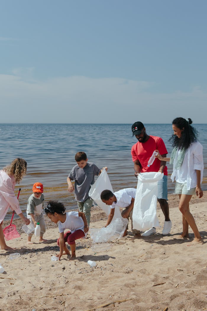 Diverse group of families clean a beach, promoting community and environmental awareness.